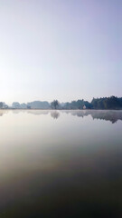 Fishing lake in the foggy morning