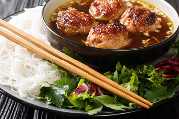 Bun cha is a Vietnamese dish of grilled pork, noodle and herb closeup in the plate on the table....