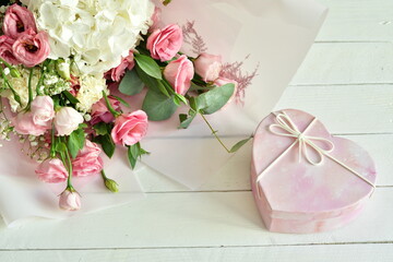 bouquet of delicate pink flowers and gift or present box . Flowers.Greeting card for Birthday, Woman or Mothers Day. I love you concept.Good morning.Selective focus.Copy space.