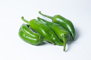 Green hot peppers on a white background. Several green hot peppers are lying next to each other. Healthy vegetables