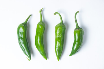 Green hot peppers on a white background. Several green hot peppers are lying next to each other. Healthy vegetables