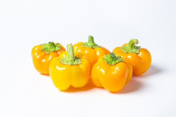 yellow pepper on a white background. Several yellow peppers lie next to each other. Healthy vegetables