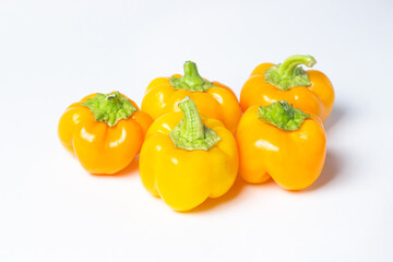 yellow pepper on a white background. Several yellow peppers lie next to each other. Healthy vegetables