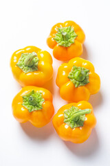 yellow pepper on a white background. Several yellow peppers lie next to each other. Healthy vegetables