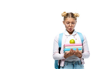 Excited kid in eyeglasses looking at apple and books isolated on white