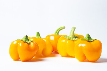 yellow pepper on a white background. Several yellow peppers lie next to each other. Healthy vegetables