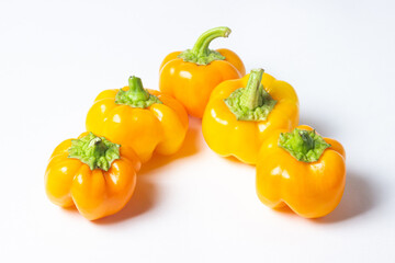 yellow pepper on a white background. Several yellow peppers lie next to each other. Healthy vegetables