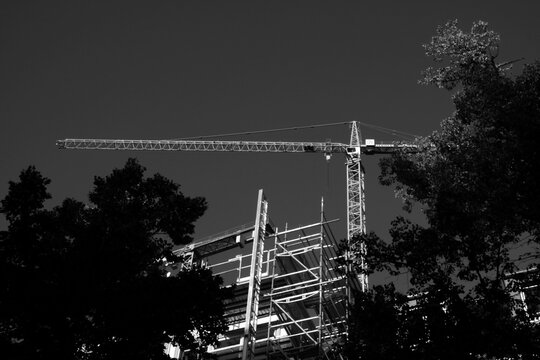 Baukran an der Baustelle eines Hochhaus mit Baugerüst im Sonnenschein am 27. August 2020 im Westend von Frankfurt am Main in Hessen, fotografiert in klassischem Schwarzweiß