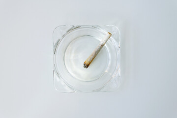Rolling cigarette turned off in an ashtray. Smoking concept. Marijuana joint.