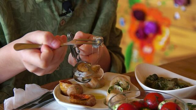 man eating a dish of snails