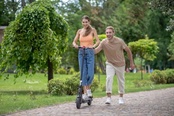 Obraz premium Young man teaching his girlfriend to ride a scooter