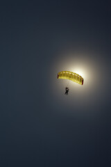 Silhouette of a parachute canopy during a tandem jump against the backdrop of a dazzling solar...