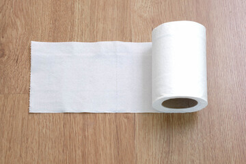 Toilet paper on the wooden table background.