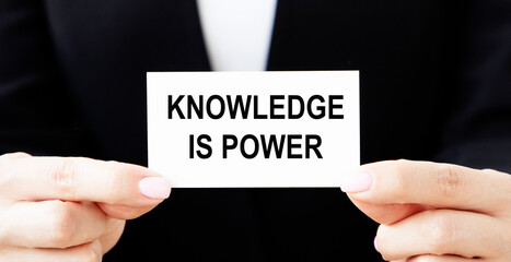 Knowledge is Power inscription on the business card, which is held in front of the businessman.