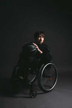 Male paraplegic athlete with basketball in wheelchair
