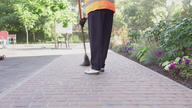A cleaning lady on the street removes garbage. Cleanliness and order in the yard depends on the janitor during quarantine.	
