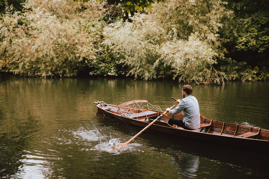 Man rowing canoe on tranquil River Avon, Bath, Somerset, UK
