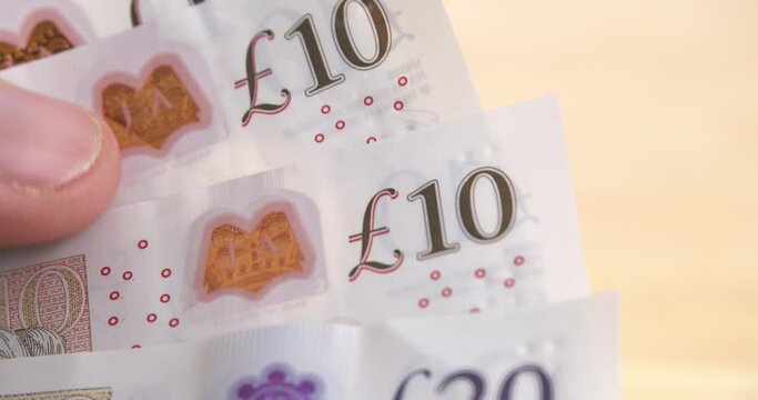 Closeup shot of British Money. Male holding English Pound Sterling notes