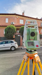 Haciendo trabajos de topografía en una calle de un pueblo para obtener superficie y forma de la parcela
