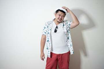 Studio shot of happy tourist man smiling while wearing hat and sunglasses
In a white background.
Holiday traveler concept