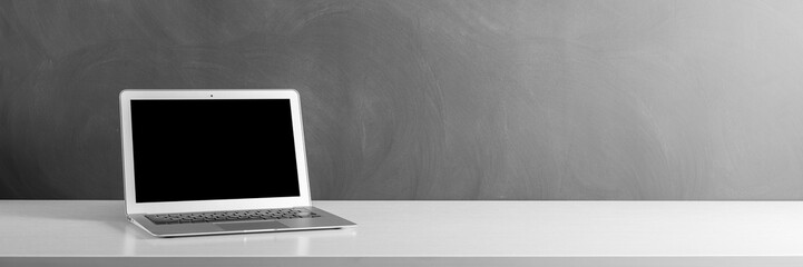 modern laptop computer on the tabl on the blackboard background
