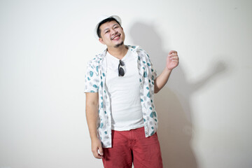 Studio shot of happy tourist man smiling while wearing hat and sunglasses
In a white background.
Holiday traveler concept