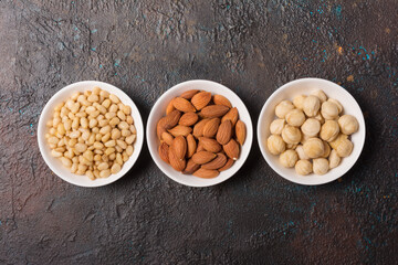White bowls with nuts as snack or ingredient for tasty dessert, meal