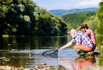 Fishing on the lake. fly fish hobby of men. retirement fishery. happy fishermen friendship. Catching and fishing. retired dad and mature bearded son. Two male friends fishing together