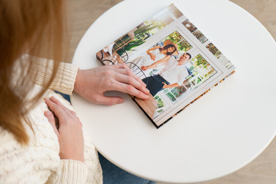 a pregnant woman flips through a photo book from a family pregnancy photo shoot. beautiful and convenient storage of photos. memory of an important period.