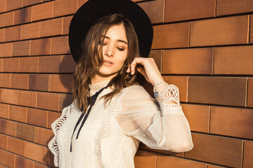 Miss with hat on a brick background