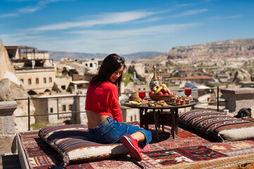 Beautiful girl in a red sweater and jeans is resting in Turkey. Beautiful view of the mountains