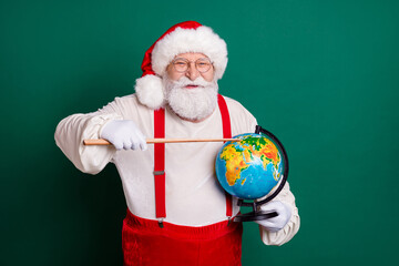 Portrait of his he nice handsome cheerful smart clever bearded fat Santa teacher holding in hands globe pointing country continent ecology lesson map planet science isolated green color background