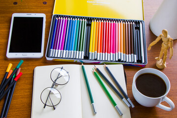 Drawing table, sketching pencils and sketchbook, empty paper and colorful pencils