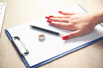 Hands of wife, husband signing decree of divorce, dissolution, canceling marriage, legal separation documents, filing divorce papers or premarital agreement prepared by lawyer.