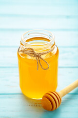 Jars of honey on blue wooden table. Vertical foto