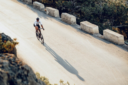 Professional cyclist on a mountain road at sunrise