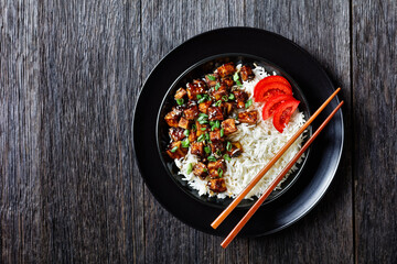 Asian teriyaki tofu with rice in a bowl, flat lay