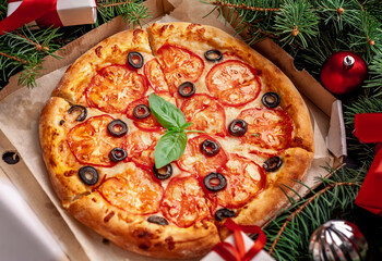 Christmas pizza margarita with Christmas decorations, gifts, spruce, toys