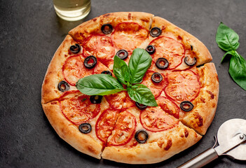 pizza margarita with basil on a stone background