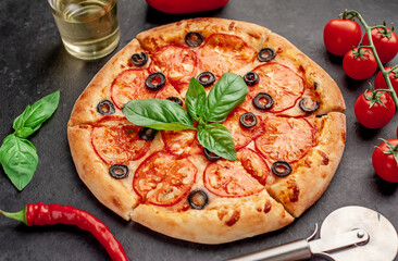 pizza margarita with basil on a stone background
