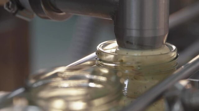 Closeup shot of process of packing food into small bottles.Food Industry closeup stock footage.