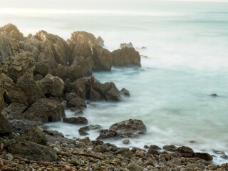 Fototapeta na wymiar Stones with silky water in the sea.