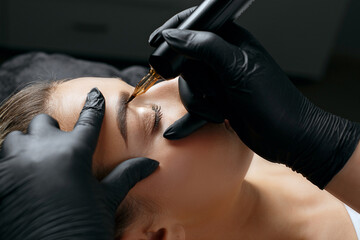 Closeup  shot of a woman applying permanent makeup - obrazy, fototapety, plakaty