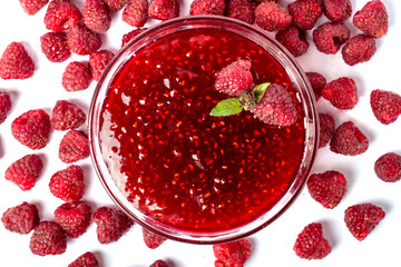 raspberry jam in a glass plate on a white background