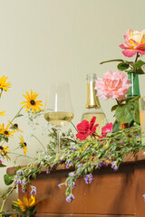 A glass and a bottle of prosecco among many colorful flowers, to suggest the complexity of wine's scents