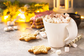 Christmas background. A cup of hot cocoa with marshmallows and Christmas baking on a stone countertop.  Copy space.