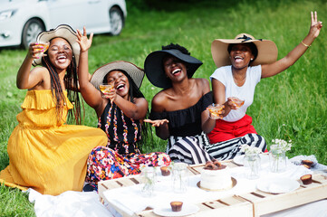 Group of african american girls celebrating birthday party and clinking glasses outdoor with decor.