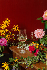 A glass of prosecco among many colorful flowers