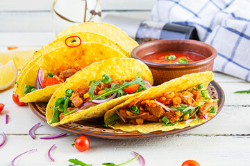 Mexican tacos with corn tortilla and meat on wooden background