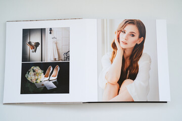 open wedding photo book. flipping through a photobook with thick pages on a white table. convenient, beautiful and long-lasting storage of photos from photo sessions.